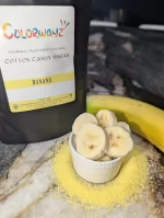 Colorwayz Banana Cotton Candy Sugar paired with fresh banana slices, showcasing the fruity, natural ingredients used for cotton candy.